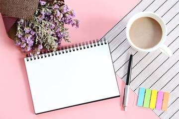 Business, planning, spring or summer concept : Top view or flat lay of open notebook paper, bouquet of dried wild flowers and coffee cup on desk table with copy space ready for adding or mock up
