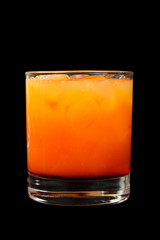 A multicolored, two-layered opaque cocktail in a low glass with ice cubes, with the taste of tomato, pineapple, and orange Side view Isolated black background. Drink for the menu restaurant, bar, cafe