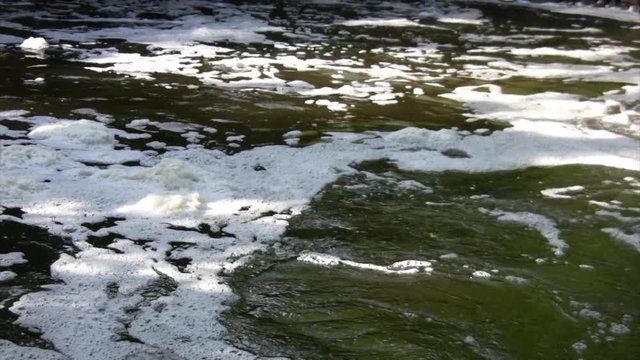 stream of foamy and polluted water, top vier, close up, with audio