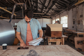 Young artisan coming up with new designs in his workshop