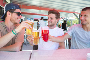 3 male friends at the bar terrace during summer