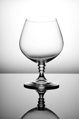Empty glass for cognac on a gray background.
