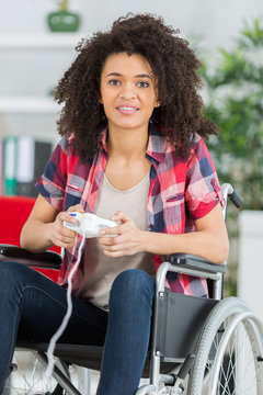 female in wheelchair playing video games at home