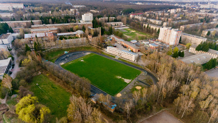 Aerial view of the city stadium among the buildings.