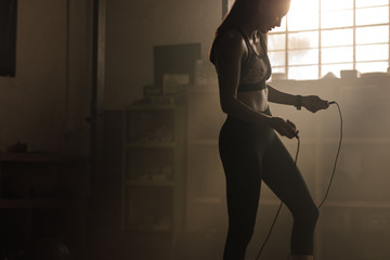 Female exercising with skipping rope at gym - obrazy, fototapety, plakaty