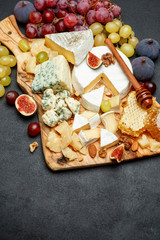 Camembert cheese with honey, figs, walnuts on wooden board