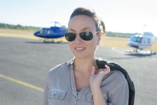 smiling woman near an elicopter