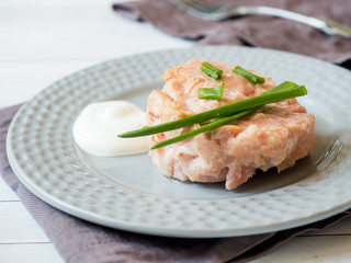 Canned tuna in its own juice with green onions on a plate. selective focus
