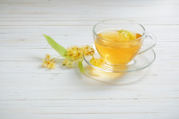 tea with linden on white wooden background