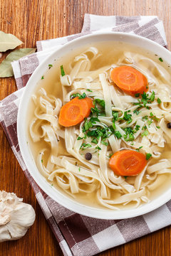 Tasty meat broth with noodles, carror and parsley