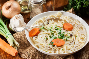 Tasty meat broth with noodles, carror and parsley