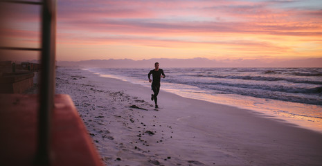 Man running on the beach in morning