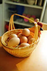 Chicken eggs in a wicker basket. Fresh chicken eggs in wicker basket on the table in the kitchen.