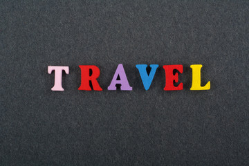 TRAVEL word on black board background composed from colorful abc alphabet block wooden letters, copy space for ad text. Learning english concept.
