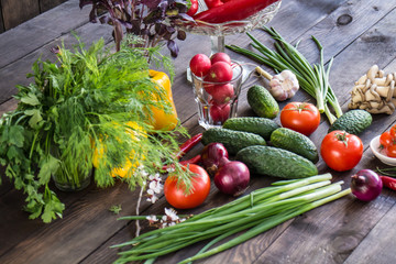 Onions, peppers, dill, tomatoes, cucumbers, radishes, dill, rucola and mushrooms on a wooden dark background