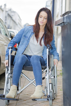 young woman in a wheelchair alone in a city