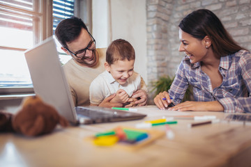 Smiling family drawing together at home