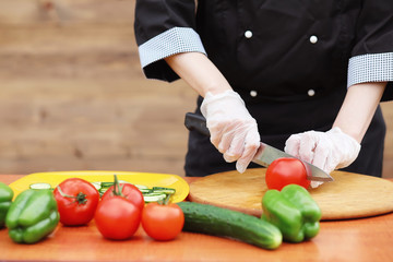 The cook cuts fresh farm vegetables