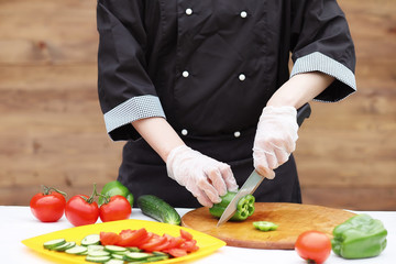 The cook cuts fresh farm vegetables