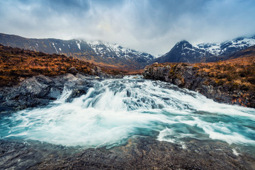 Fototapeta premium Waterfall and mountain at Fairy Pool in Isle of Skye, Scotland