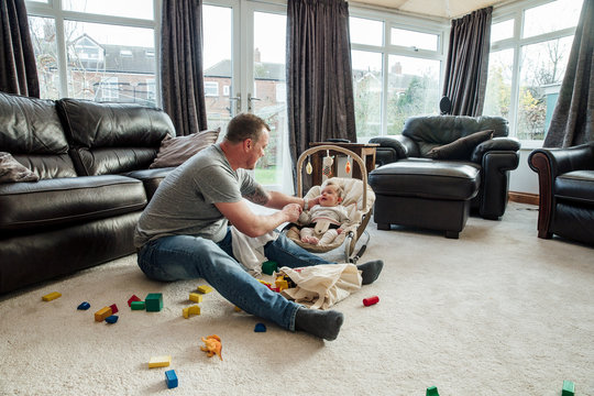 Father Relaxing at Home with his Baby Daughter
