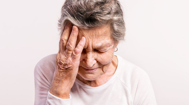 Studio Portrait Of A Senior Woman In Pain. Close Up.