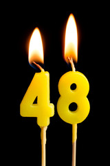Burning candles in the form of 48 forty eight (numbers, dates) for cake isolated on black background. The concept of celebrating a birthday, anniversary, important date, holiday, table setting