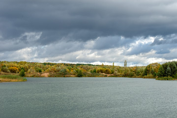 Autumn landscape. Autumn trees at the bank of the river in sunny autumn day