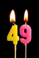 Burning candles in the form of 49 forty nine (numbers, dates) for cake isolated on black background. The concept of celebrating a birthday, anniversary, important date, holiday, table setting