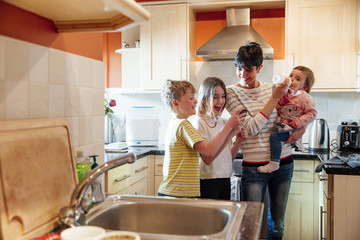Naklejka premium Multitasking Mum with her Children at home