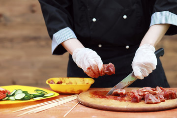 The cook cuts meat for cooking barbecue
