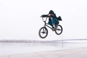 BMX freestyle. The toddler jumps on a BMX bike. BMX rider makes tricks on the background of the...