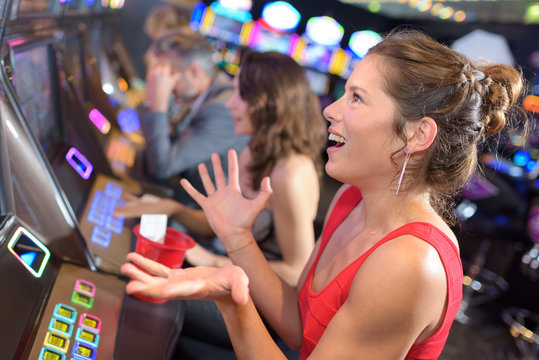 beautiful woman in red dress playing slot machine