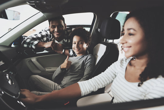 African American Family At Car Dealership. Father, Mother And Son In New Car, Smiling.