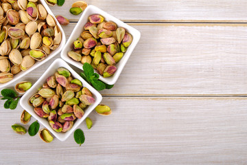 Pistachios on white wooden background with copy space