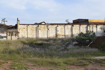 Fototapeta na wymiar Muro de edifício antigo abandonado em lote vazio