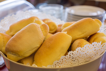 Close-up of fresh bread in a bowl and dishes in the background