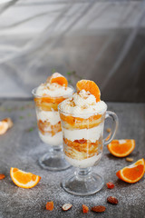 Dessert in a glass with tangerines and whipped cream