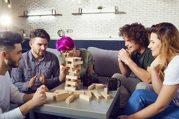 A cheerful group of friends play board games in the room.