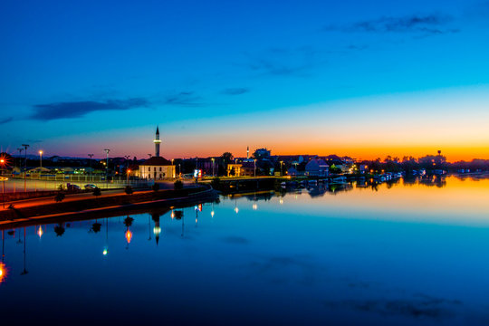 Sunset over city with reflections on river