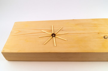 Eight matches in the shape of a star were placed on the surface of the wooden board.
