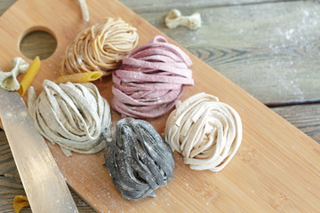 Raw homemade pasta on wooden background