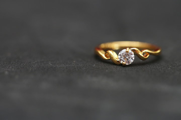 Diamond with gold ring on black floor
