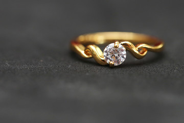 Diamond with gold ring on black floor