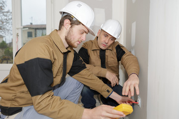 builders using a yellow multimeter to calibrate house