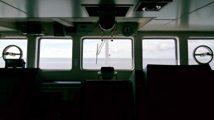 Silhouette of the ship's bridge with sea and sky infront of the windows.