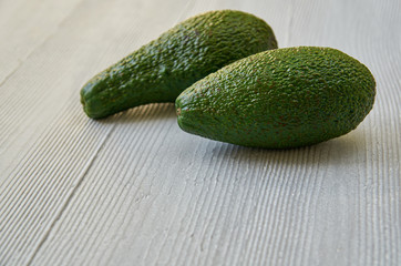Fresh whole avocados on the gray background with free copy space. Healthy food. Close up view