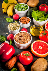 Healthy food background, trendy Alkaline diet products - fruits, vegetables, cereals, nuts. oils, dark blue concrete background copy space