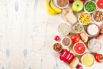 Fototapeta na wymiar Diet food background concept, healthy carbohydrates (carbs) products - fruits, vegetables, cereals, nuts, beans, light concrete background above copy space
