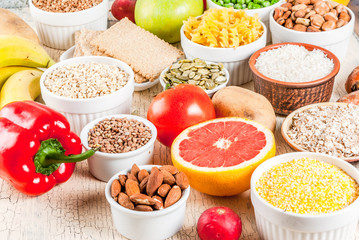 Diet food background concept, healthy carbohydrates (carbs) products - fruits, vegetables, cereals, nuts, beans, light concrete background